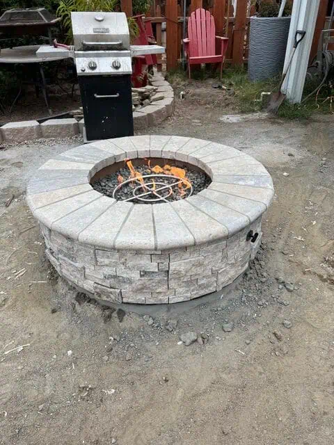 Fire pit with brick surround for outdoor patio and backyard entertainment.