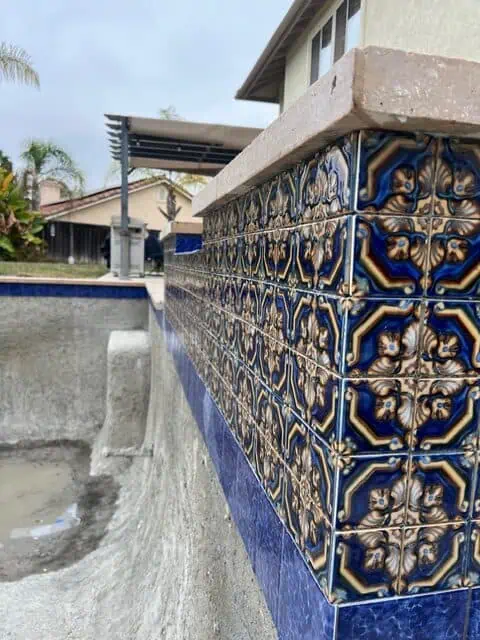 Decorative ceramic tiles enhance the pool area with vibrant colors and detailed designs.