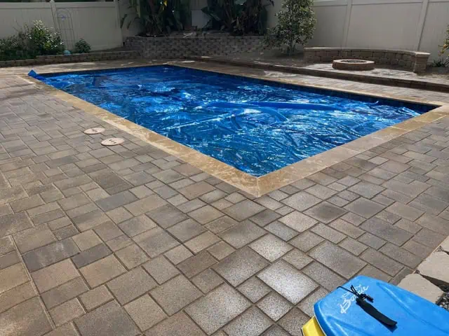 Custom backyard pool renovation with new tile and decking by GFG Remodeling.