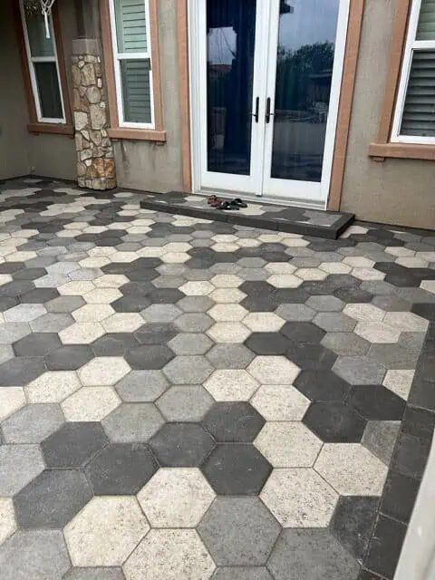 Beautiful hexagon-shaped paver patio with a mix of gray, beige, and dark gray stones.